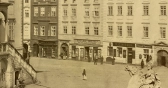 Fotografie východní části radnice a části Horního náměstí, v pozadí knihkupectví Eduarda Hölzela a další obchody kolem roku 1864. (SOA, Sbírka obrazového materiálu a fotografií Olomouc, inv. Č. 1235, sign. X/4).